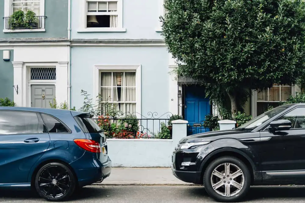 Two parked cars in front of house